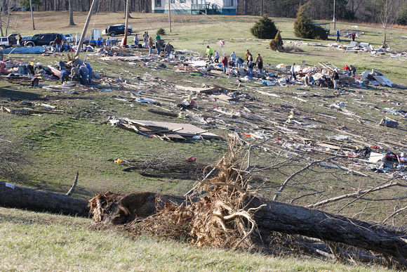 Volunteers comb through the debris of homes where several people died in tornado destruction in East Bernstadt, Kentucky,