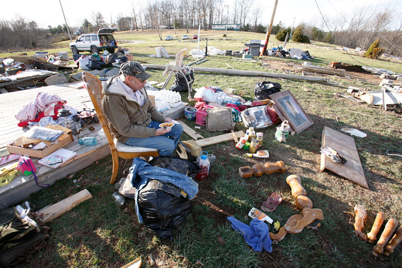 Randell Chadwell sits amidst what used to be his home after Tornado destruction in East Bernstadt, Kentucky
