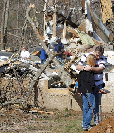Gary Cross comforts his sister Charlotte Evans in front of the remains of the house where their sister Melissa Evans died near Crossville, TN