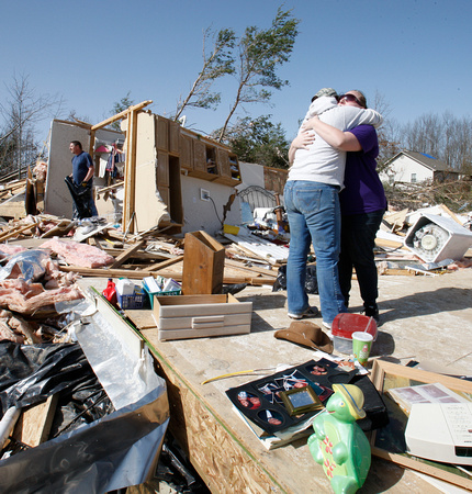 Shelia Skaggs and Kelly Hatheway hug amidst the remains of the home where their mother/grandmother died near Crossville, TN